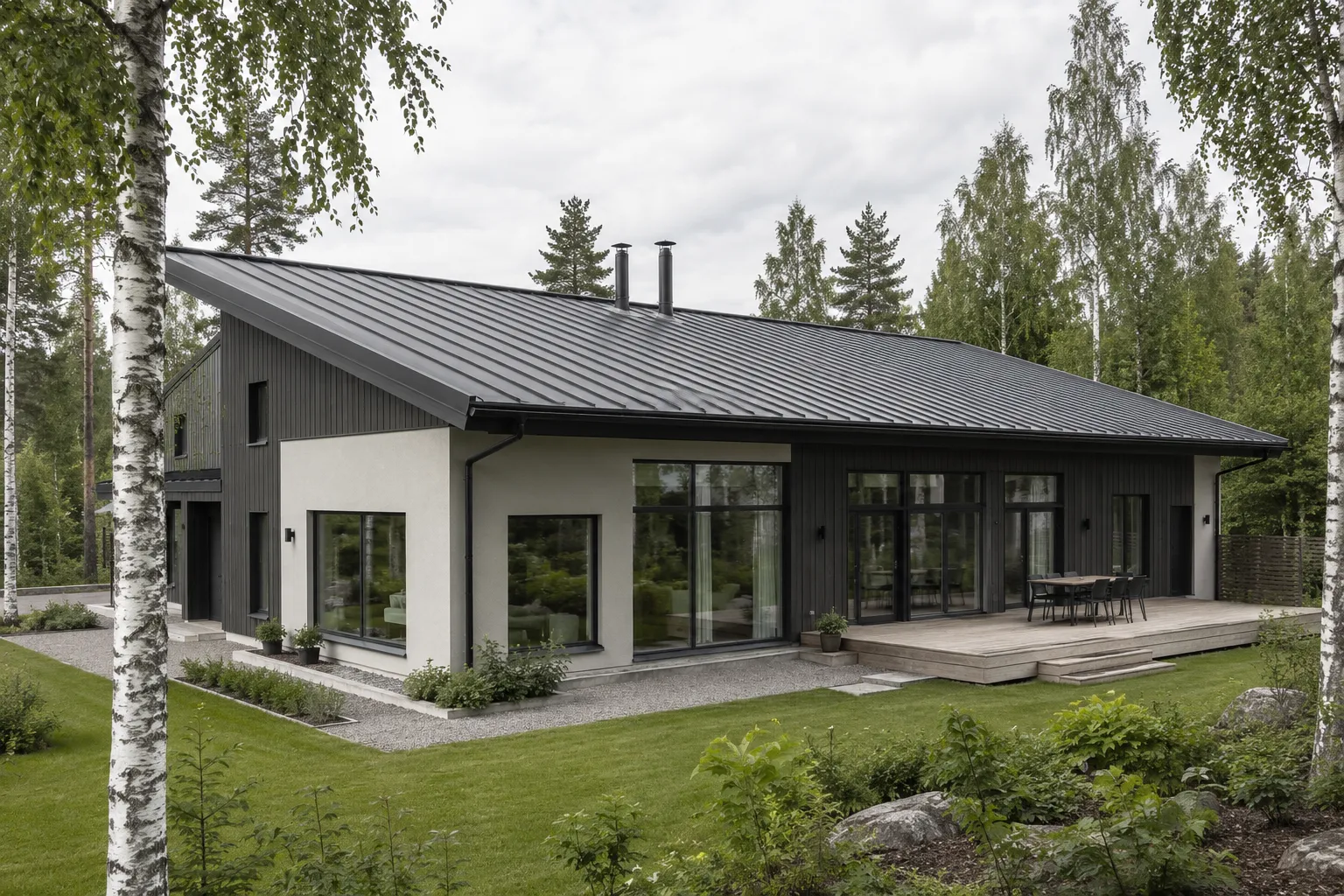 Moderni omakotitalo koivujen keskellä, loivalla harjakatolla grafiitinharmaa konesaumattu peltikate, julkisivussa vaalea rappaus ja tumma pystylautaverhous.